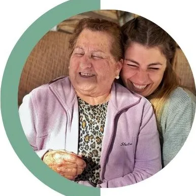 Mujer mayor sonriendo abrazada a Inés Bertrand